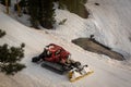 Snowcat getting winched up a steep slope at a mountain Royalty Free Stock Photo