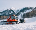 Snowcat - Red caterpillar vehicle for maintenance of mountain ski slopes in the background ski slope. Royalty Free Stock Photo