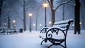 Snowcovered black wroughtiron park bench with curved armrests in a winter park during snowfall Royalty Free Stock Photo