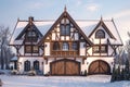 A snowcovered house with many windows stands under cloudy sky