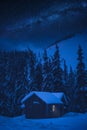 Snowcovered wooden house at night