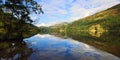 Snowdonian mountains and Cloudy blue skies reflected in Peaceful Llyn Gwynant