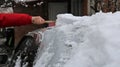 shoveling snow off the roof of a car