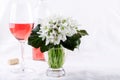 Snowdrop bouquet, white spring flowers and pink wine on light background. Copy space Royalty Free Stock Photo