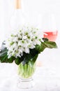 Snowdrop bouquet, white spring flowers and pink wine on light background. Copy space Royalty Free Stock Photo