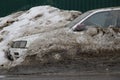 Snowdrop - a car abandoned on a muddy roadside in a snowdrift Royalty Free Stock Photo