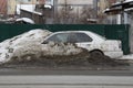 Snowdrop - a car abandoned on a muddy roadside in a snowdrift Royalty Free Stock Photo