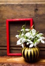 Snowdrop flowers in a vase on rustic wooden background Royalty Free Stock Photo