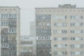 snowfall on the background of poor suburban apartment houses in the city