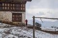 The snowfall in the Buddhist monastery Phadjoding high in Himalaya mountains in Bhutan, a monk in traditional red clothes Royalty Free Stock Photo