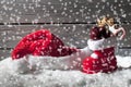 Snowfall with christmas hat and boot on heap of snow against wooden background