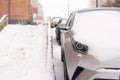 Snowfall in the city cars in the snow on the street