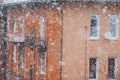 Snowfall in the city. Defocused heavy snowfall, yellow residential building blured in the background. Heavy snow concept Royalty Free Stock Photo