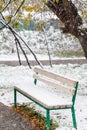 Snowfall and first snow on bench in city park Royalty Free Stock Photo