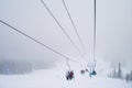 Skiers on the chairlift route while snowfall