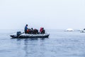 Snowfall over the Zodiac boat with frozen polar divers near Almirante Brown, Antarctic peninsula