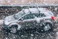 Snowfall on the road. Blurred heavy snowfall with snowflakes in the foreground and a car in the background. Blizzard. Concept on p