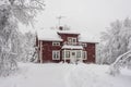 Snowfall in the village. Blurred background. Old wooden house in the snow. Traditional typical Scandinavian Swedish house or villa Royalty Free Stock Photo