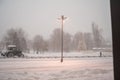 Snowfall in the winter. Snow blizzard in the city. Lantern, tree in the city, clearing the snow in the city