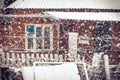 Snowfall Winter Weather in village with snowflakes and old house window