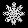 Snowflake cut out of paper on a black background Royalty Free Stock Photo