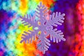A sparkling white Christmas decoration on a shiny colourful background. Royalty Free Stock Photo