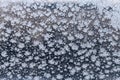 Snowflake and frost on frozen windowpane in winter