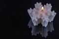 Snowflake-shaped candle on black glass