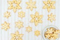 Snowflake-shaped sugar icing Christmas cookies on a white tablecloth with golden stripes. Royalty Free Stock Photo