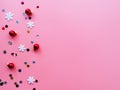 Snowflakes, confetti and red Christmas balls on a pink background, flatly, copyspace. Bright Christmas holiday concept. New year` Royalty Free Stock Photo