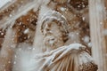 Snowflakes Falling on an Ancient Statue in Winter Royalty Free Stock Photo