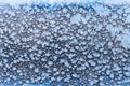 Snowflakes and frost pattern on frozen window pane Royalty Free Stock Photo