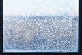 Snowflakes and frost pattern on frozen windowpane Royalty Free Stock Photo