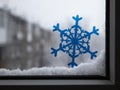 Snowflakes on the glass window on the background of the snow-covered city. Royalty Free Stock Photo