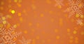 Snowflakes and glowing lens flare on abstract orange background