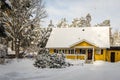 Snowflakes heaven. Snowfall in village. Beautiful two story wooden country house in yellow color with large windows, outdoor terra Royalty Free Stock Photo