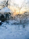 Snowflakes in the window sunset wooden house garden trees in winter Royalty Free Stock Photo