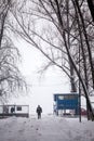 Snowing landscape in the park with people passing by