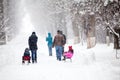 Snowing landscape in the park with people passing by