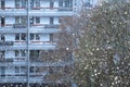 snowing outside against backdrop of multi-story building, urban landscape, winter weather conditions and snowfall, video shooting