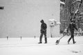 Snowing urban landscape with people passing by Royalty Free Stock Photo