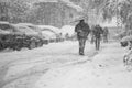 Snowing urban landscape with people passing by Royalty Free Stock Photo