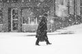 Snowing urban landscape with woman passing by