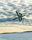 Snowkiter doing a freestyle trick while snowkiting with ski in winter conditions and beautiful sky