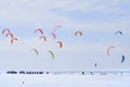 Snowkiting competitions with colored parachutes on a frozen river covered with snow in winter Royalty Free Stock Photo