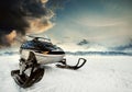 Snowmachine on the mountain lake frozen surface with thunderstorm clouds on the background