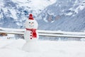 Snowman in Alps mountains. Snow man building fun in winter mountain landscape. Family outdoor activity in snowy cold season.