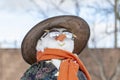 Snowman in Asian clothes, sunglasses and straw hat in the yard.
