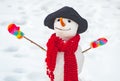 Snowman on a background snow-covered fir branches. Making snowman and winter fun. Cute snowman at a snowy village. Happy Royalty Free Stock Photo