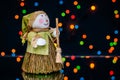 Snowman with a broom on a background of colored lights